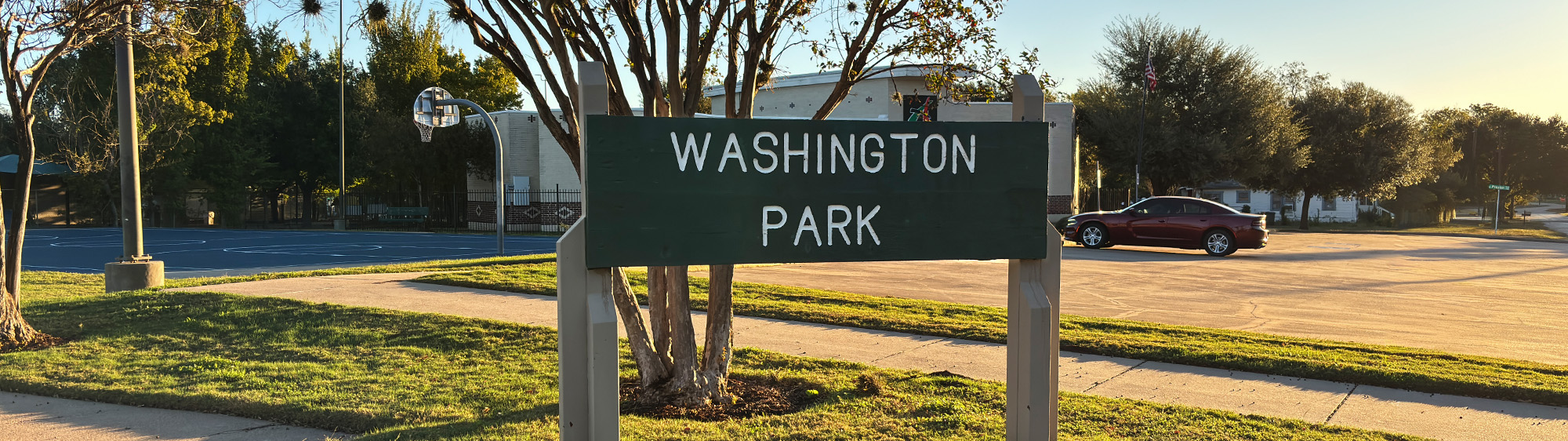 Washington Park sign in front of a basketball court and the Brazos Valley African American Museum.
